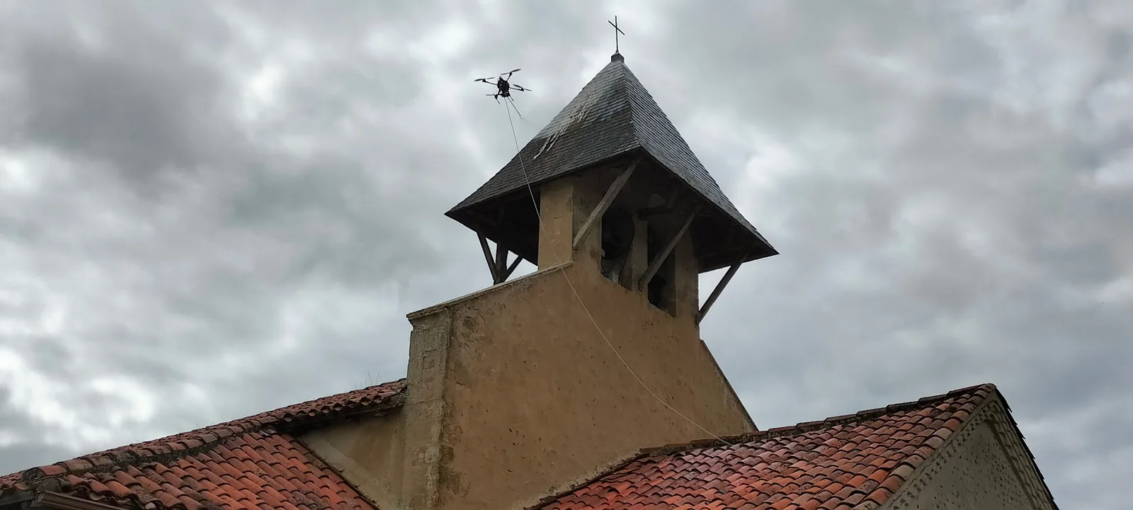 Drone de nettoyage en intervention près d'un clocher d'église